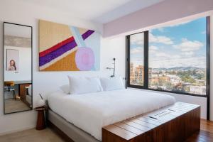 危地马拉Good Hotel Guatemala City的一间卧室设有一张大床和一个大窗户