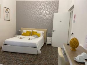 卡塔尼亚Sleep Inn Catania rooms - Affittacamere的卧室配有一张带黄色枕头的大型白色床。