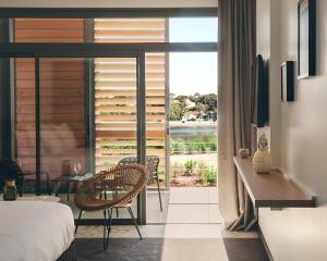 奥瑟戈尔Hôtel & Spa Villa Seren的一间卧室设有一张床和一个美景阳台