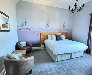 爱丁堡Straven Guesthouse的一间卧室配有一张大床和一把椅子