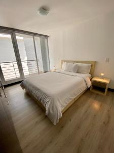 基多水边公寓的白色的卧室设有一张大床和一个大窗户