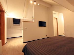 滑铁卢One bedroom apartement with wifi at Waterloo的一间设有床铺和墙上电视的房间