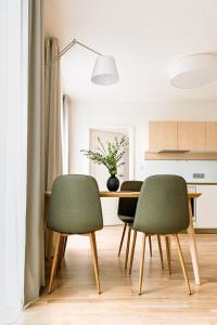 布尔诺Apartment Brno的厨房里配有一张餐桌和两张绿椅