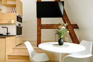 布尔诺Apartment Brno的厨房以及带白色桌椅的用餐室。