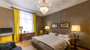 慕尼黑剧院酒店的一间卧室配有一张床、一台电视和吊灯。