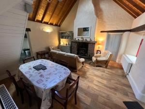 ManorhamiltonCarraun Cottage的客厅配有桌子和壁炉