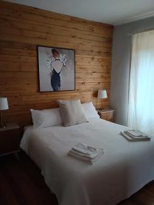 TollegnoAntico Affittacamere di Tollegno的卧室配有白色的床和木墙
