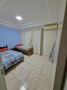 皮萨拉斯Casa a 500 metros da praia em balneário piçarras的卧室配有1张床,铺有瓷砖地板。