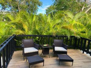 璜多里奥Beach Apartment Villas Jubey, Emotion access的一个带椅子和桌子的庭院,并种植了棕榈树
