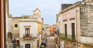 CarmianoTre Balconi - Casa Vacanza Salento的城市中一条设有停泊车辆的小巷的景色