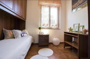 普拉塔莫纳La casa delle janas的卧室配有一张床、一张书桌和窗户。