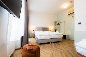 布拉格贝拉尼克酒店的酒店客房,带一张床和行李箱