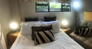 赫克托斯普雷特Gecko Cottages的卧室配有带两盏灯的白色床