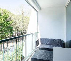 拉格朗德默特Bleu soleil * Clim * Parking privé * Chambre * Terrasse的阳台配有沙发和大窗户。