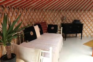 阿曼福德Gilfach Gower Farm Luxury Yurt with Hot Tub的蒙古包内一间卧室,配有一张白色的床