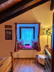 GignodMeizon - La Montagna, Pila, Crevacol, Aosta e Valpelline的卧室前设有带沙发的窗户