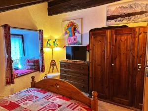 GignodMeizon - La Montagna, Pila, Crevacol, Aosta e Valpelline的一间卧室配有一张床和一个带电视的梳妆台