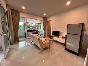 春蓬Naisang Hostel的客厅配有椅子和冰箱