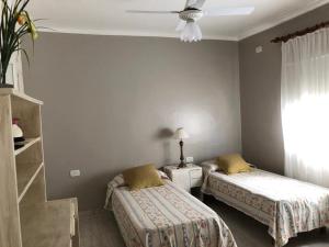 圣地亚哥-德尔埃斯特罗Piedra Rosada的一间卧室配有两张床和吊扇