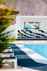 佩里沃罗马克兹尼斯别墅的一座带桌椅的游泳池位于酒店大楼旁