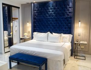 雷诺萨Hotel Posada San Antonio的一间卧室配有一张大床和蓝色床头板