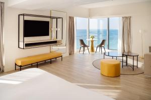 阿雷西费阿瑞斯弗格兰酒店及水疗中心的酒店客房设有一张床和一间带电视的客厅。