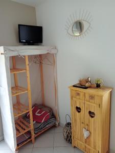 PendéLa salicorne的一间房间,配有书桌和架子上的电视