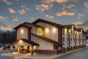 WaynesburgSuper 8 by Wyndham Waynesburg - Recently Renovated!的停车场里灯火通明的大建筑