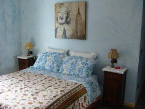 BovesLa Coccinella B&B的卧室配有一张床,墙上挂有绘画作品