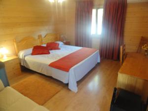 Villarrubio圣因西德罗旅馆的一间卧室配有一张带红色枕头的床