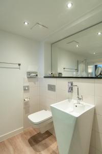 赛巴特班森Hotel am Fischerstrand的白色的浴室设有卫生间和水槽。
