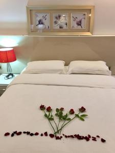 ÇekirgeYankı Hotel的一张白色的床,上面有一束玫瑰花