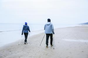 济夫努夫Jantar Medical Spa的两个人在海滩上散步