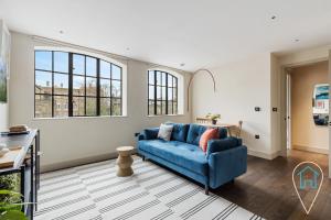 伦敦Modern 1BR home in Islington!的客厅设有蓝色的沙发和窗户。