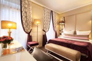 巴黎香榭丽舍大道伽利略酒店的酒店客房配有一张床铺和一张桌子。