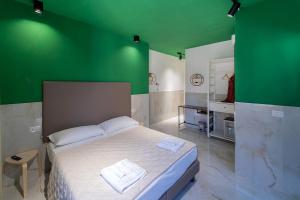 那不勒斯P.C. Boutique H. Vesuvius, Napoli Centro, by ClaPa Group的一间卧室设有绿色的墙壁和一张床