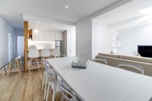 波瓦-迪瓦尔津Rua da Praia的厨房以及带桌椅的起居室。