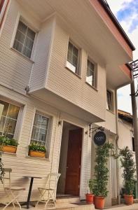 ÇekirgeYankı Hotel的前面有两把椅子的白色房子