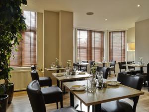 牛津Linton Lodge a BW Signature Collection Hotel的餐厅设有桌椅和窗户。