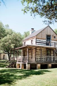 弗雷德里克斯堡Contigo Ranch Fredericksburg的古老的小木屋,设有门廊和甲板