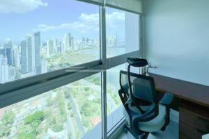 巴拿马城Apartamento Amoblado en Cinta costera Panama largas estadias的窗户前带椅子的房间