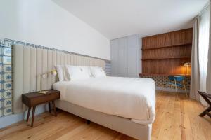 布拉加LP Heritage Apartments的卧室配有一张白色大床和一张书桌