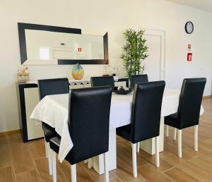 托里迪蒙科尔武Casa da Tapada的一间配备有白色桌子和黑色椅子的用餐室