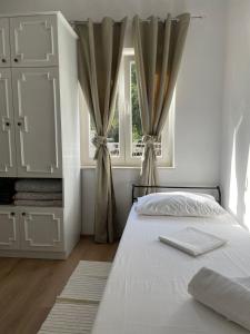 图兰杰Holiday house Fila的白色的卧室设有床和窗户
