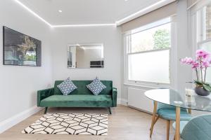 伦敦LuxLet Apartments - Heart of Hampstead, London的客厅配有绿色沙发和桌子