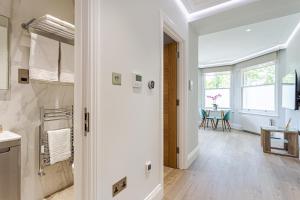 伦敦LuxLet Apartments - Heart of Hampstead, London的白色的浴室,走廊上设有桌子