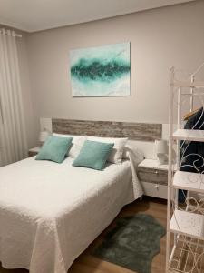 Rincón de SotoMi Rincón Favorito VT-LR1594的一间卧室配有带白色床单和蓝色枕头的床。