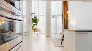 布拉迪斯拉发Eurovea Apartments的一间厨房,配有白色橱柜和一间餐厅