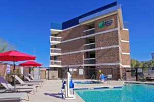 坦培Holiday Inn Express & Suites Phoenix - Tempe, an IHG Hotel的酒店前方的游泳池配有椅子和遮阳伞