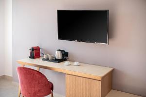 干尼亚M City Hotel的客房设有书桌、电视和椅子